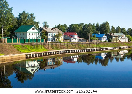 An ancient Russian town of Tikhvin. Reflection of old russian houses in waters of the river.