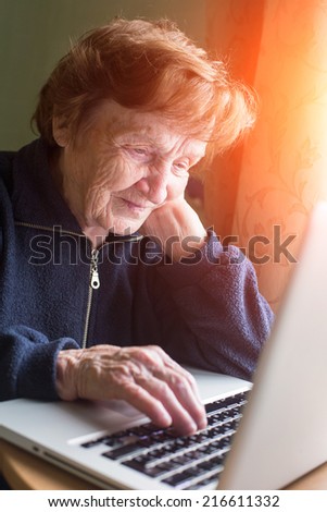 Old woman checks the mail on a laptop.