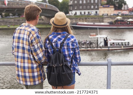 Young romantic couple on the river bank in a old city. Traveling in Europe.