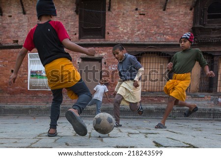 KATHMANDU, NEPAL - DEC 9, 2013: Unknown children play football after lesson at Jagadguru School. School established at 2013, to let new generation learn Sanskrit and preserve Hindu culture.