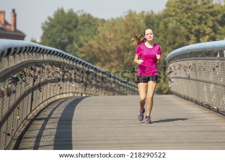 Happy cute girl fitness model runner working out jogging. Running in the City.