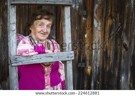 Old woman in Slavic folk clothes on his farm in the village.