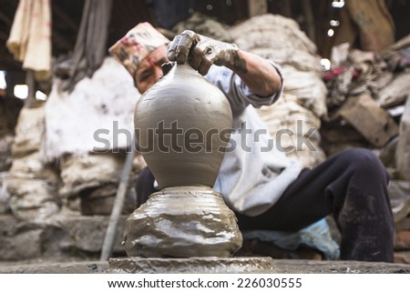 BHAKTAPUR, NEPAL - DEC 7, 2013: Unidentified Nepalese man working in the his pottery workshop. More 100 cultural groups have created an image Bhaktapur as Capital of Nepal Arts.