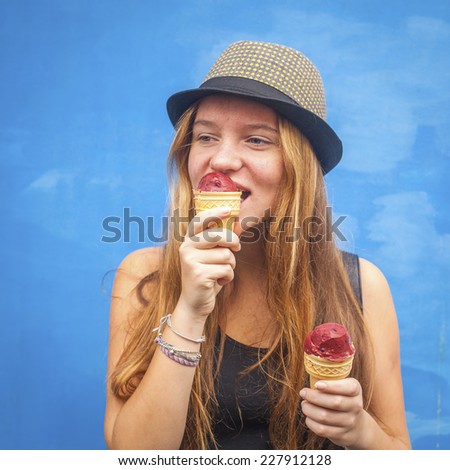 Nice teengirl with ice cream, blue wall background (Instagram style series)