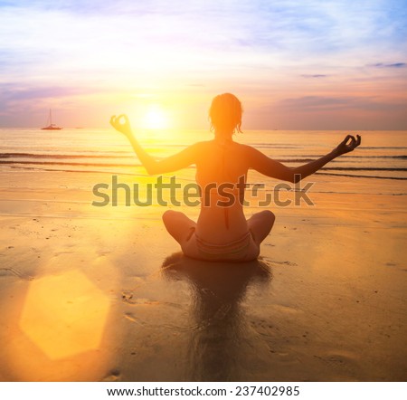 Silhouette of a woman yoga on sea sunset.