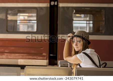 Young girl is waiting at the station a train. Travel concept.