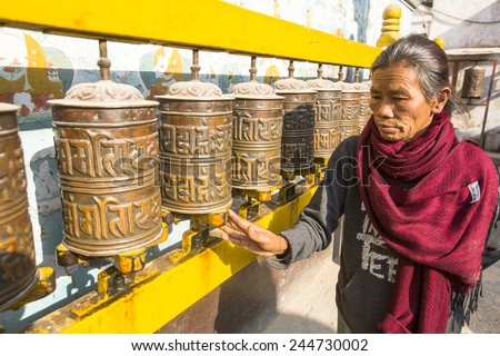 KATHMANDU, NEPAL - DEC 11, 2013: Unidentified old woman near stupa Boudhanath. Stupa is one of the largest in the world, of 1979 is a UNESCO World Heritage Site.