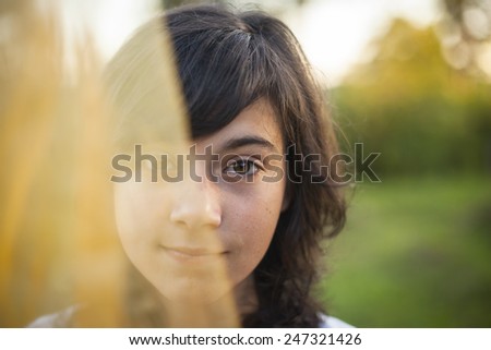 Young cute girl portrait half face hidden behind a veil.