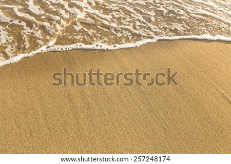 Texture of beach sea sand with a soft wave of surf.