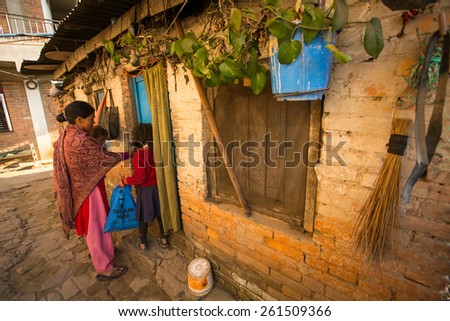 KATHMANDU, NEPAL - CIRCA DEC, 2013: Unidentified local people near their home in a poor area of the city. The caste system is still intact today but the rules are not as rigid as they were in the past
