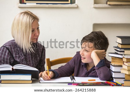 Tutor teaches a young student with his studies.