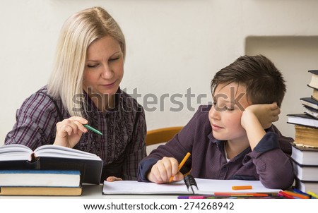 Schoolboy studying with the help of a tutor.