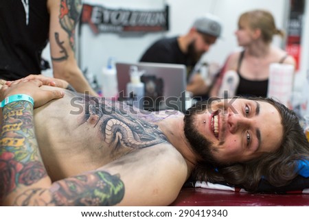 KRAKOW, POLAND - JUNE 6, 2015: People make a tattoos at the 10-th International Tattoo Convention in the Congress-EXPO Center. This year anniversary TattooFest is tattoo Studio with an area of 2000m2.