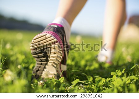 Close-up sole running shoe on green grass in a sunny day.