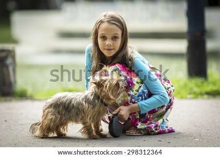 Portrait of cute little girl on a walk with her little dog.