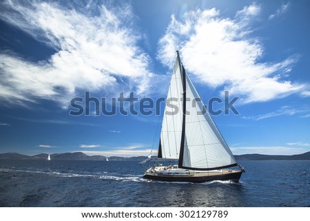 Sailing ship yachts with white sails in the open Sea. Luxury lifestyle.