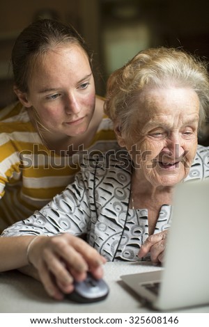 Granddaughter teaches her grandmother to work on the computer.