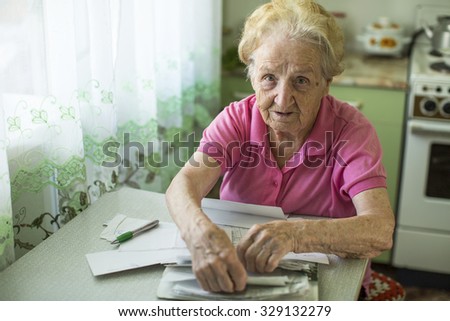 Elderly woman with bills to pay utilities.