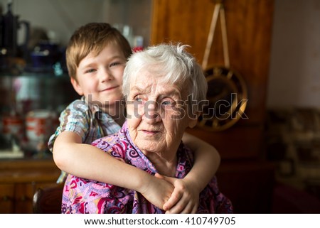 Portrait of an elderly woman with a small grandson in the background.