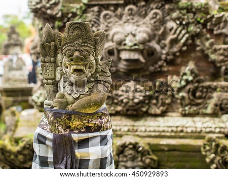 Traditional demon guards statue carved in stone on Bali.