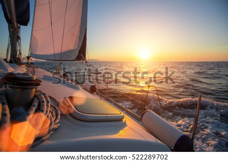 Sailing ship luxury yacht boat in the Sea during amazing sunset.