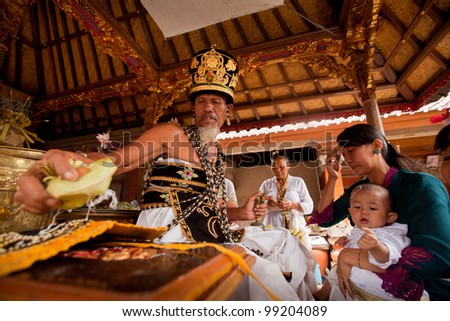 BALI, INDONESIA - MARCH 28: Unidentified child during the ceremonies of Oton - is the first ceremony for baby's on which the infant is allowed to touch the ground on March 28, 2012 on Bali, Indonesia.