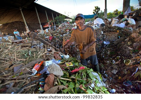 BALI, INDONESIA - APRIL 11: Poor people from Java island working in a scavenging at the dump on April 11, 2012 on Bali, Indonesia. Bali daily produced 10,000 cubic meters of waste.