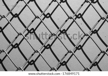 Obsolete gray grunge concrete closed with chain link fence and shadows