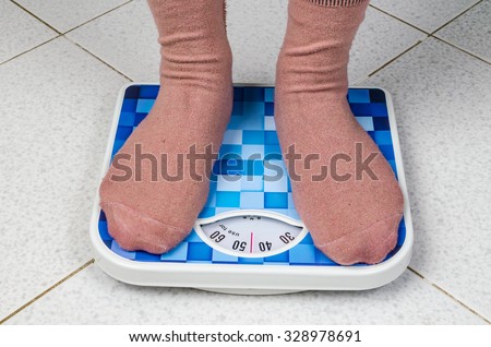 weight woman standing on a retro style weighing machine