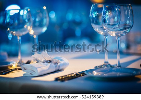 Luxury Table setting focus on the glass blue background.