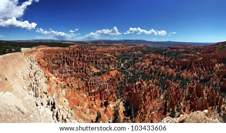 A panorama of the Hoodoo rock spires of Bryce Canyon, taken from Inspiration Point, with blue sky and fluffy clouds. Utah, USA