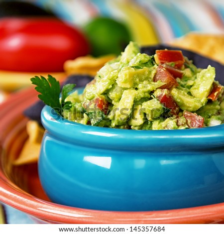 A Bowl Of Fresh Guacamole With Corn Tortilla Chips. Intentional Shallow Depth Of Field.
