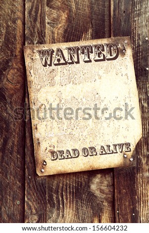 Old wood background with faded wanted poster attached. Space for your text.