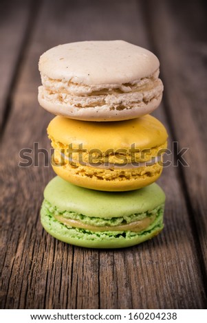 Assorted macaroons over old wood background. Vintage effect processing with intentional vignetting