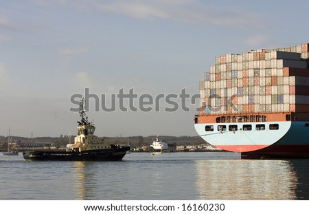 Container ship being brought into port by tug boats, Southampton, England