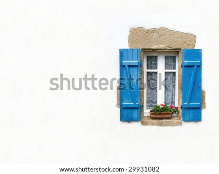 Blue shuttered window on white stucco wall with geraniums in window box. Space for text.