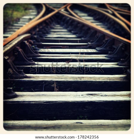 Closeup of train tracks and sleepers. Filtered to look like an aged instant photo.