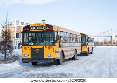 MONTREAL, CANADA - 16 JAN: School buses parked up in the snow and ice wait to collect school children. Montreal, Canada, on 16th January 2015