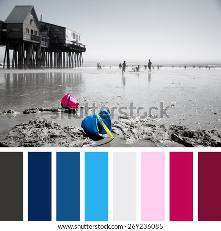 Discarded children\'s buckets on Old Orchard Beach, Maine, USA. Faded effect photo with selective colour highlighting the buckets. In a colour palette with complimentary colour swatches.