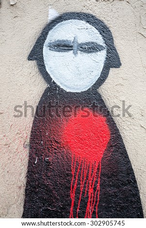 PARIS, FRANCE - MARCH 3RD: Graffiti figure of a man with a red blood splattered heart, on the wall of an alley in Montmatrtre, 18th Arrondissement. On March 3rd 2015.