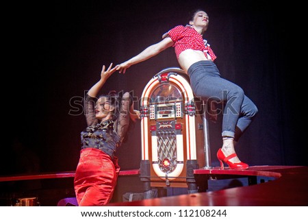 AURILLAC, FRANCE - AUGUST 22: two women dance on a bar under a big top as part of the Aurillac International Street Theater Festival,show by the Company Off ,on august 22, 2012, in Aurillac,France.