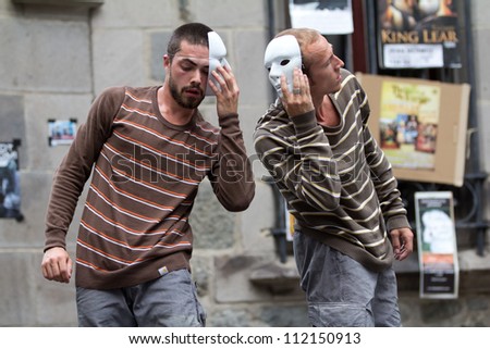 AURILLAC, FRANCE - AUGUST 24: two masked dancers, side to side, as part of the Aurillac International Street Theater Festival,show by the Company Idem,on august 24, 2012, in Aurillac,France.