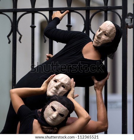 AURILLAC, FRANCE - AUGUST 23: enigmatic and worrying actors wearing a white mask, Aurillac International Street Theater Festival, show La diagonale du Fou, on august 23, 2012, in Aurillac,France.