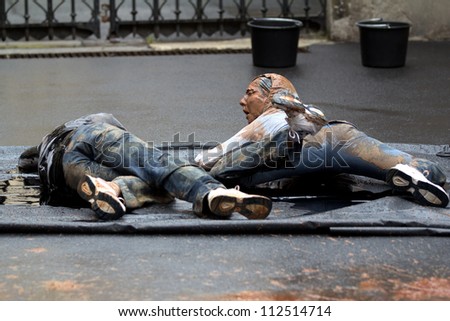 AURILLAC, FRANCE - AUGUST 22: Two dirty dancers move in the street as part of the Aurillac International Street Theater Festival, show named Vachement, on august 22, 2012, in Aurillac,France.