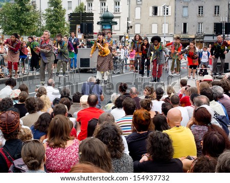 AURILLAC, FRANCE - AUGUST 23: actors perched on bar stools in the middle of the crowd,as part of the Aurillac International Street Theater Festival, Cie Oposito,on august 23, 2013, in Aurillac,France