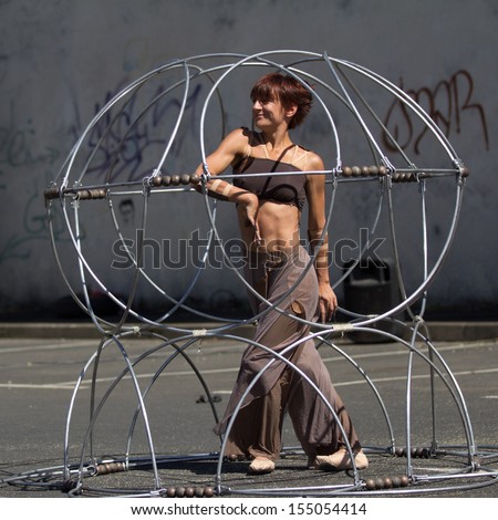 AURILLAC, FRANCE - AUGUST 22: a prisoner moves inside a metallic structure as part of the Aurillac International Street Theater Festival, Company Eclektic,on august 22, 2013, in Aurillac,France
