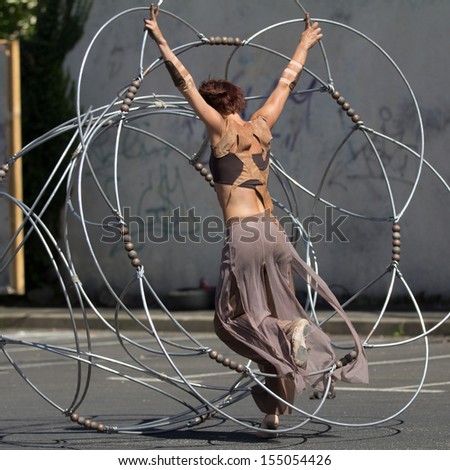 AURILLAC, FRANCE - AUGUST 22: a dancer moves in the middle of a metallic structure as part of the Aurillac International Street Theater Festival, Cie Eclektic,on august 22, 2013, in Aurillac,France
