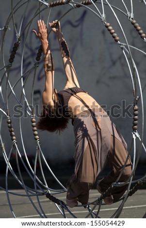 AURILLAC, FRANCE - AUGUST 22: a dancer moves inside a metallic structure,as part of the Aurillac International Street Theater Festival,Cie Eclektic,on august 22, 2013, in Aurillac,France