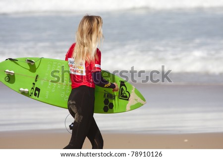 SEIGNOSSE, FRANCE - JUNE 3:  Unidentified surfer walks on the beach at the Swatch Pro France on June 3, 2011, in Seignosse, France.