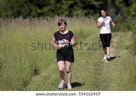 PAVIE, FRANCE - MAY 18: Two tired female runners in a field  at the Trail of Pavie, on May 18, 2014, in Pavie, France.